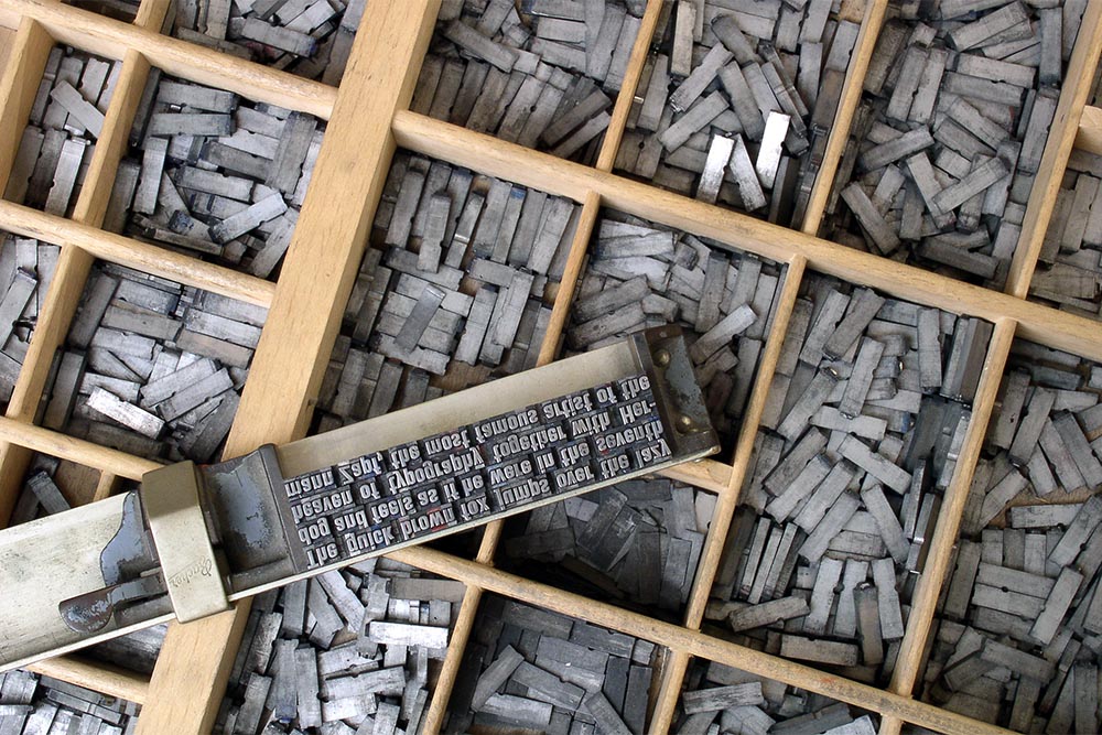 Tipos móveis metálicos organizados para impressão tipográfica.