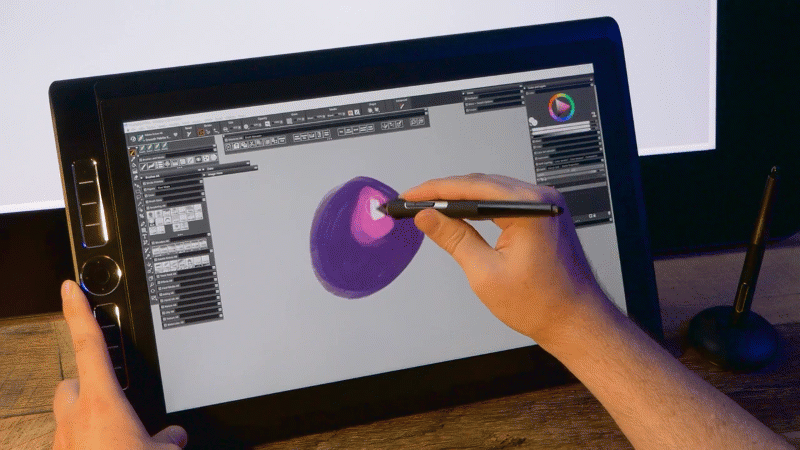 Pintando com a ponta inversa caneta sobre o monitor interativo.