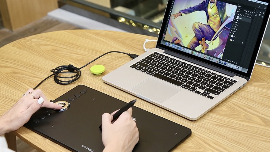 Mesa digitalizadora conectada a um notebook usando um cabo USB.